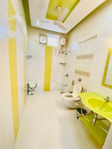 a bathroom with a yellow sink and a toilet at JAWAHAR VILLA - 2BHK - City Centre in Jodhpur
