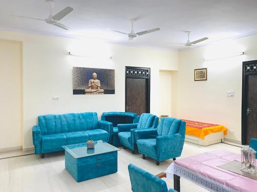a living room with blue chairs and a bed at JAWAHAR VILLA - 2BHK - City Centre in Jodhpur