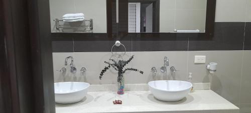 a bathroom with two sinks and two faucets at Casa Boutique HNP in Barrancabermeja