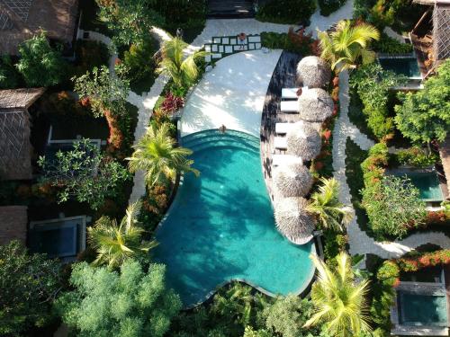 an overhead view of a swimming pool with palm trees at Gypsea Bali in Uluwatu
