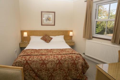 a bedroom with a bed and a window at The Inn at Emmington in Chinnor