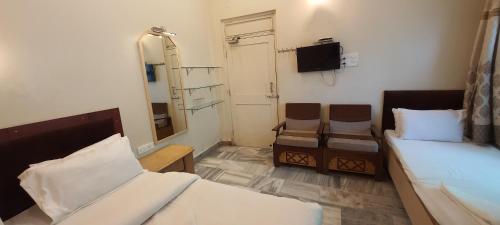 a small room with two beds and a mirror at Hotel Temple On Ganges in Varanasi