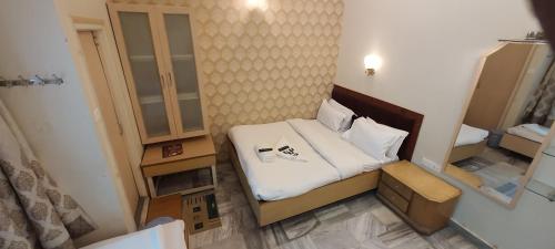 a small room with a bed and a mirror at Hotel Temple On Ganges in Varanasi