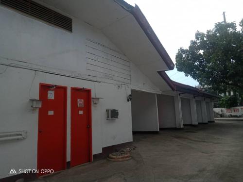 a building with red doors on the side of it at WJV INN Humay-humay in Gun-ob