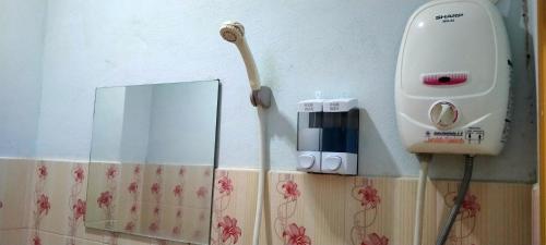 a hair dryer on a wall next to a mirror at RuengsriSiri Guesthouse in Sukhothai