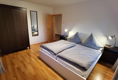 Schlafzimmer mit einem Bett mit blauen und weißen Kissen in der Unterkunft Niedergerner Alpaka Ranch in Haiming