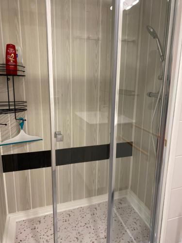 una doccia con porta in vetro in bagno di home détente a Marmande
