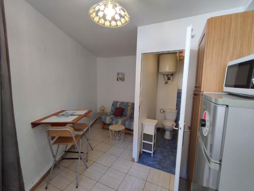 une petite cuisine avec une table et un réfrigérateur dans l'établissement Cueva, à Arles