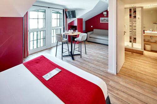 um quarto de hotel com uma cama e uma mesa com cadeiras em Hotel Donibane Saint-Jean-de-Luz em Saint-Jean-de-Luz