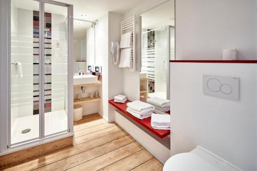 a bathroom with a shower and a toilet and a sink at Hotel Donibane Saint-Jean-de-Luz in Saint-Jean-de-Luz