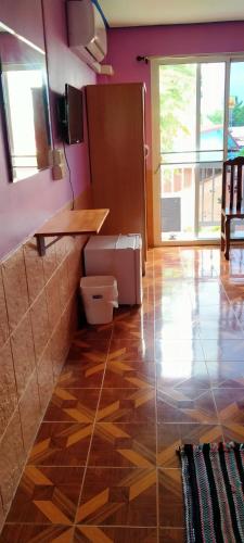 a kitchen with a wooden floor and purple walls at Rueangsrisiri Guesthouse 2 in Sukhothai