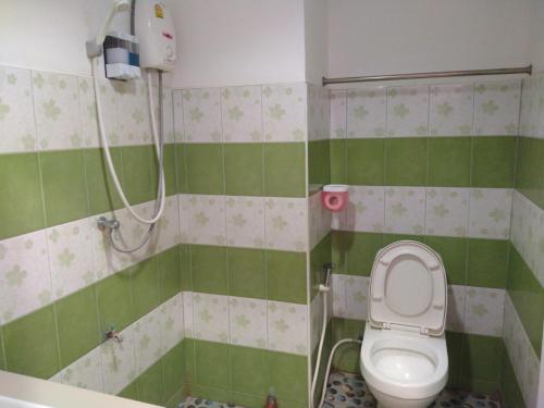 a small bathroom with a toilet and a shower at Rueangsrisiri Guesthouse 2 in Sukhothai