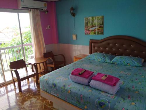 a bedroom with a bed with two pillows on it at Rueangsrisiri Guesthouse 2 in Sukhothai