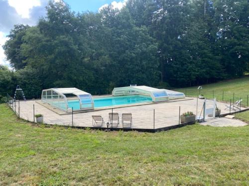 einen Pool auf einer Terrasse mit Stühlen auf einem Feld in der Unterkunft Chalets de l Empereur in Ussel