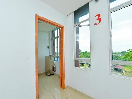 una habitación con una puerta con un número tres en la pared en Super OYO 90494 Sam Huat Hotel, en Kampong Atap