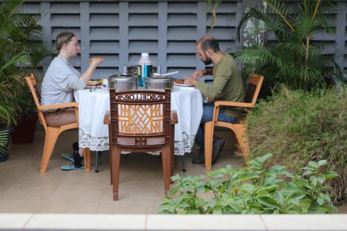 a man and a woman sitting at a table at WEST ORANGE LODGE in Moshi