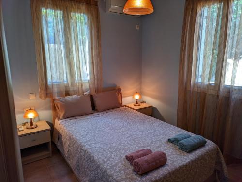 een slaapkamer met een bed met 2 kussens erop bij Sweet home of Kefalonia in Ayia Evfimia
