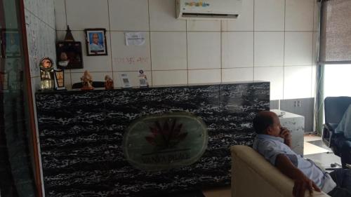 a man sitting on a couch in a waiting room at Hotel Vanya Palace By WB Inn in Agra