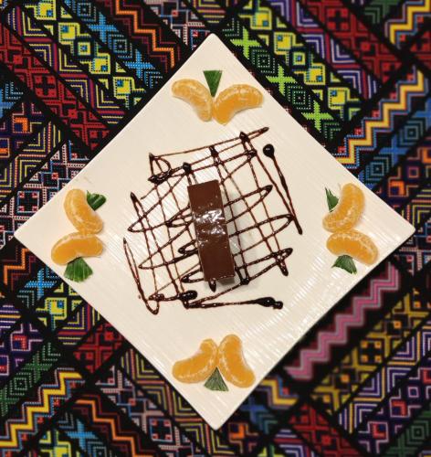 a white plate with a piece of cake and orange slices at Princess of Zanzibar in Michamvi