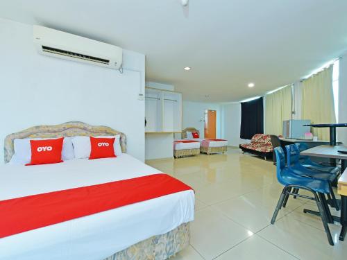 a hotel room with a bed and a table and chairs at Super OYO 90494 Sam Huat Hotel in Kampong Atap