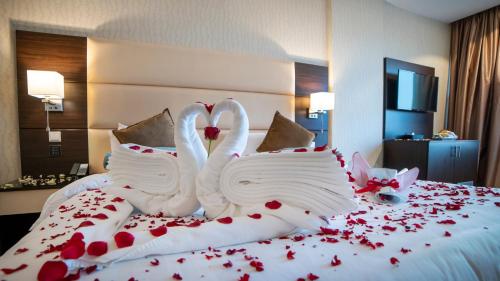 two swans made out of red roses on a bed at Holiday Villa Hail in Hail