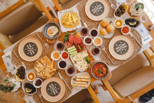 een tafel met borden met voedsel en andere voedingsmiddelen bij Voger Alaçatı Silence in Alacati