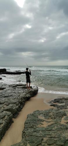 a person is standing on the rocks near the ocean at 65 @ Zeezicht in Kingsburgh