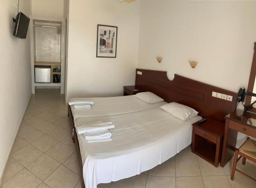 1 dormitorio con 1 cama grande y toallas. en Elpis Rooms, en Mylopotas