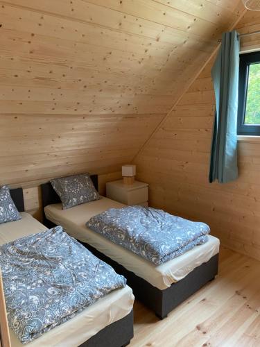 a room with two beds in a log cabin at Ośrodek Wypoczynkowy Złote Piaski in Jarosławiec