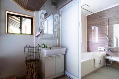 a bathroom with a sink and a toilet and a shower at 里山の花乃家 in Tanikawa