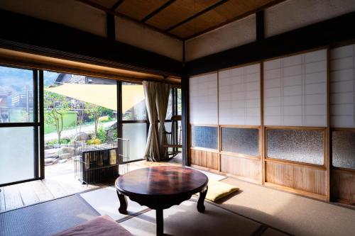 a room with a table and a large window at 里山の花乃家 in Tanikawa