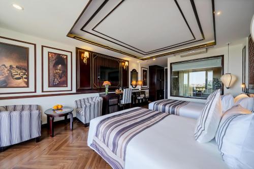 a hotel room with a bed and a desk at Le Pavillon Hoi An Luxury Resort & Spa in Hoi An