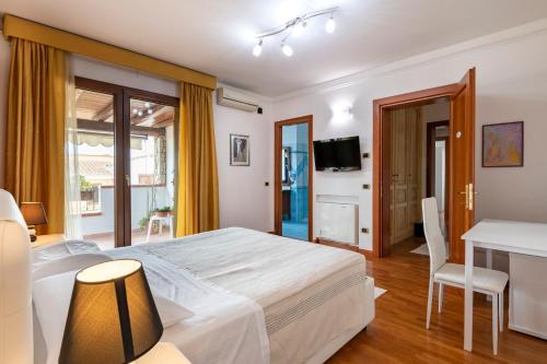a bedroom with a bed and a desk and a television at Sa Omu Bianca in Tortolì