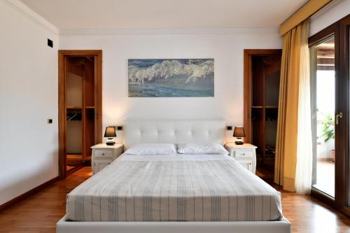 a bedroom with a white bed and two night stands at Sa Omu Bianca in Tortolì