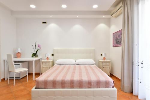 een slaapkamer met een bed, een tafel en een bureau bij Arbatax Sa Omu Bianca in Tortolì
