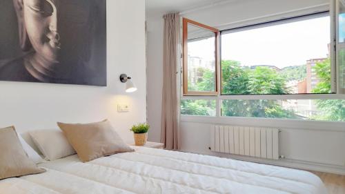 a bedroom with a large bed with a large window at Mood Bilbao Apartamentos - New & Special in Bilbao