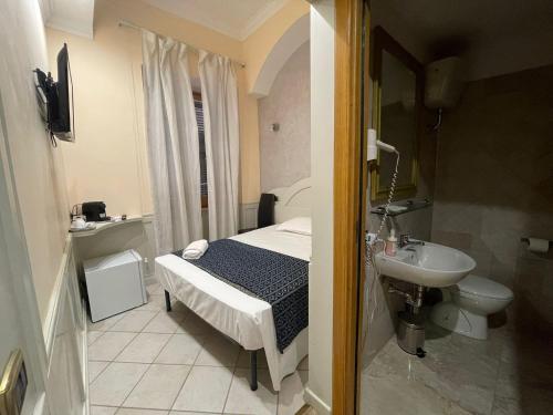 - une petite salle de bains avec un lit et un lavabo dans l'établissement Casa di Stefano, à Rome