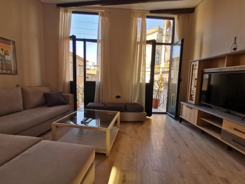 LaZaRTe في ميتيليني: غرفة معيشة مع أريكة وتلفزيون