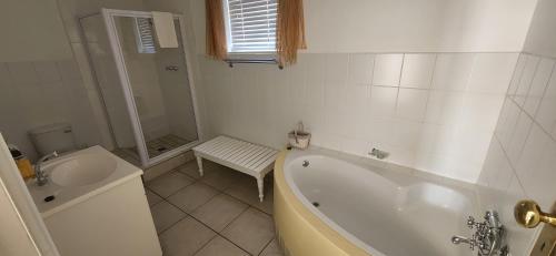 a white bathroom with a tub and a sink at Paternoster Lodge in Paternoster