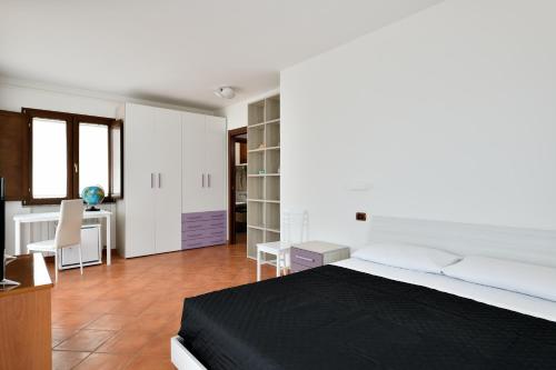 a bedroom with a large bed and a desk at Sa Omu Bianca in Tortolì