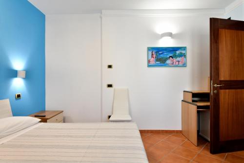 a bedroom with a bed and a picture on the wall at Sa Omu Bianca in Tortolì