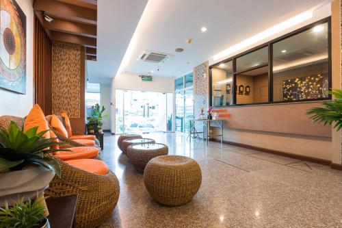 a lobby with couches and chairs in a building at 24@Home Hotel in Nonthaburi