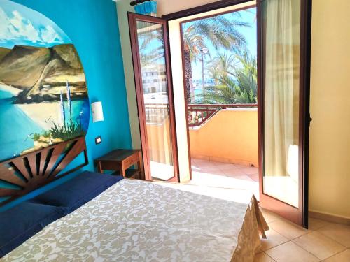 a bedroom with a bed and a view of a balcony at Puesta De Sol Residence in Lampedusa