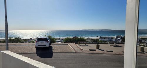 a white car parked on a street next to the beach at Paternoster Lodge in Paternoster