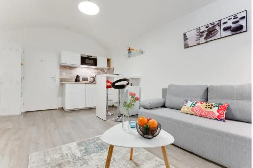 a living room with a gray couch and a table at Private Studio By Prague Hosts in Prague