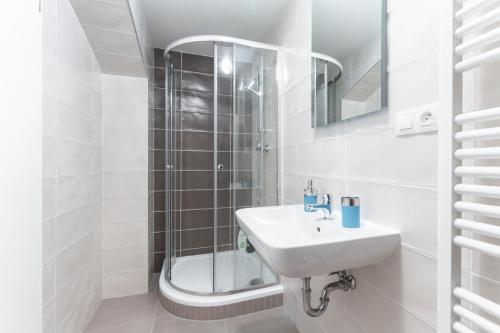 uma casa de banho branca com um lavatório e um chuveiro em Private Studio By Prague Hosts em Praga