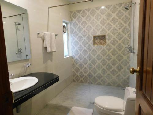 a bathroom with a sink and a toilet at Hotel SR Lounge Multan in Multan