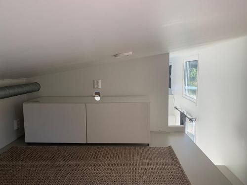 a white room with a white cabinet and a rug at Luxus Tiny House Saagala in Tornio