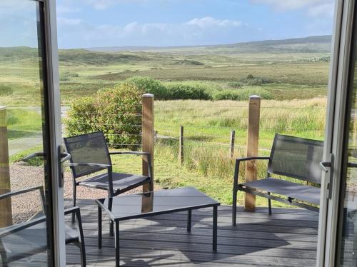 two chairs and a table on a porch with a view at deer green place in Kinloch
