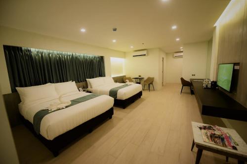 ein Hotelzimmer mit 2 Betten und einem Flachbild-TV in der Unterkunft The First Islatel in Lucap